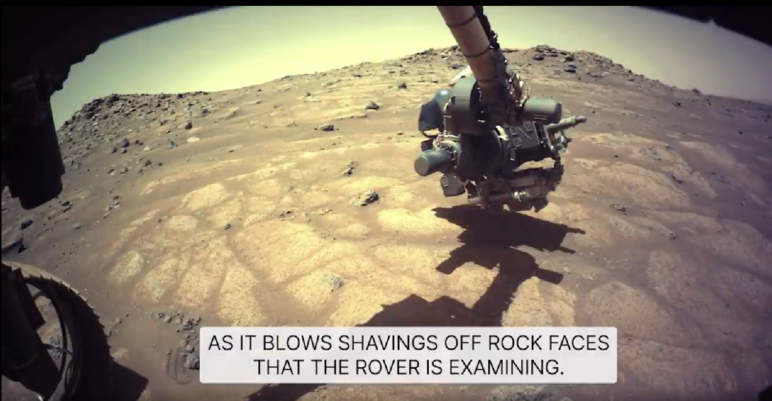 AS IT BLOWS SHAVINGS OFF ROCK FACES THAT THE ROVER IS EXAMINING.